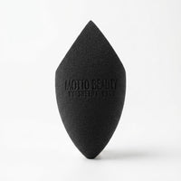 Black makeup sponge with 'Motto Beauty by Sheena' branding on a white background
